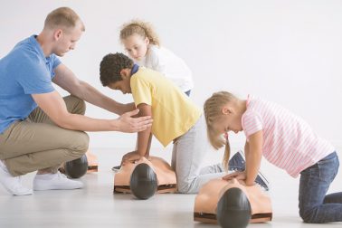 Children at school learning first aid