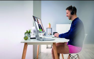 Young Businessman Using Headphone While Video Conferencing On Computer